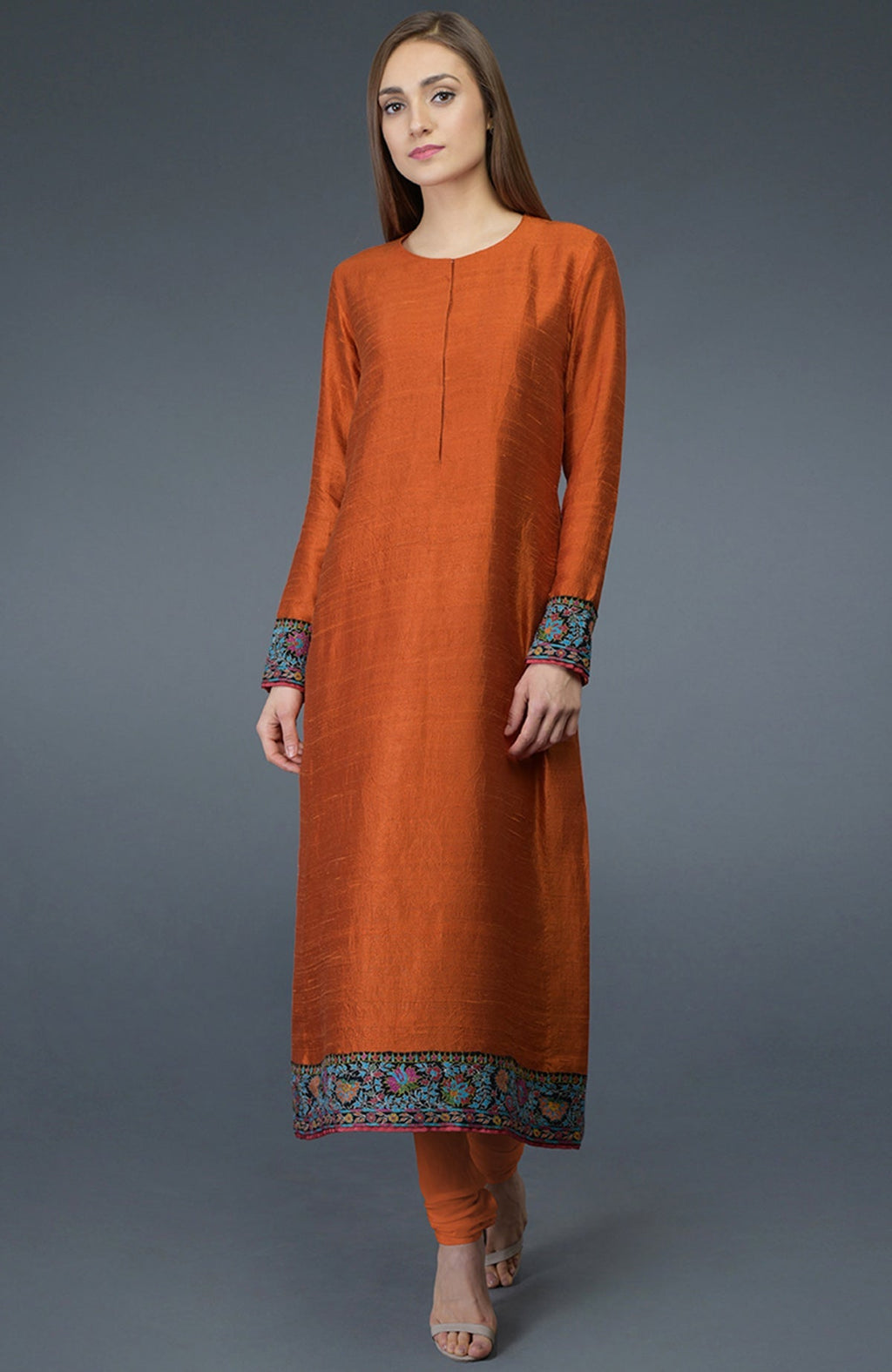 Burnt orange raw silk suit with jewel neckline and colorful Kashmiri hand embroidery on shirt and dupatta borders