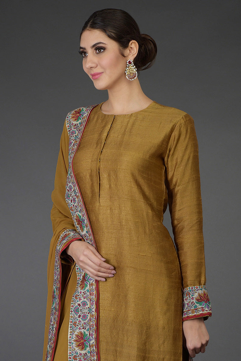 Dark mustard raw silk suit with multicolor Kashmiri hand embroidery and georgette dupatta borders.
