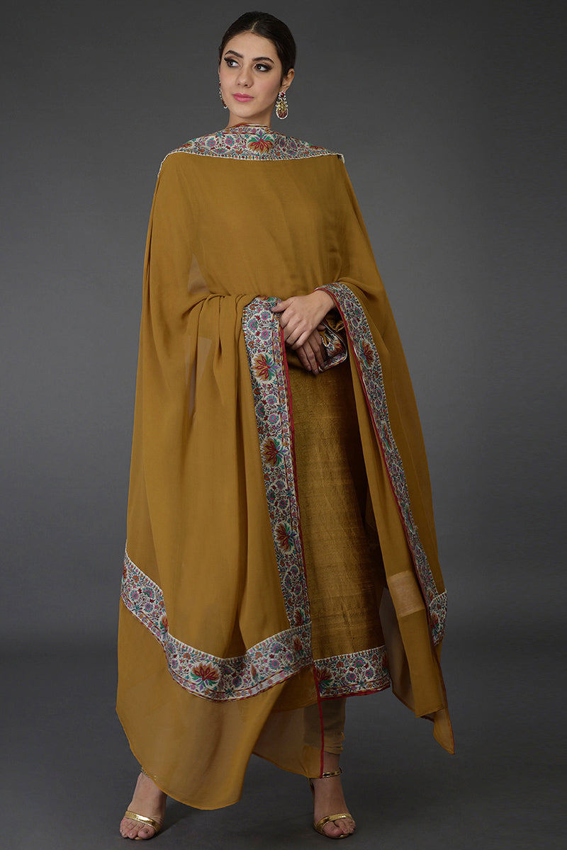 Dark mustard raw silk suit with multicolor Kashmiri hand embroidery and georgette dupatta borders.