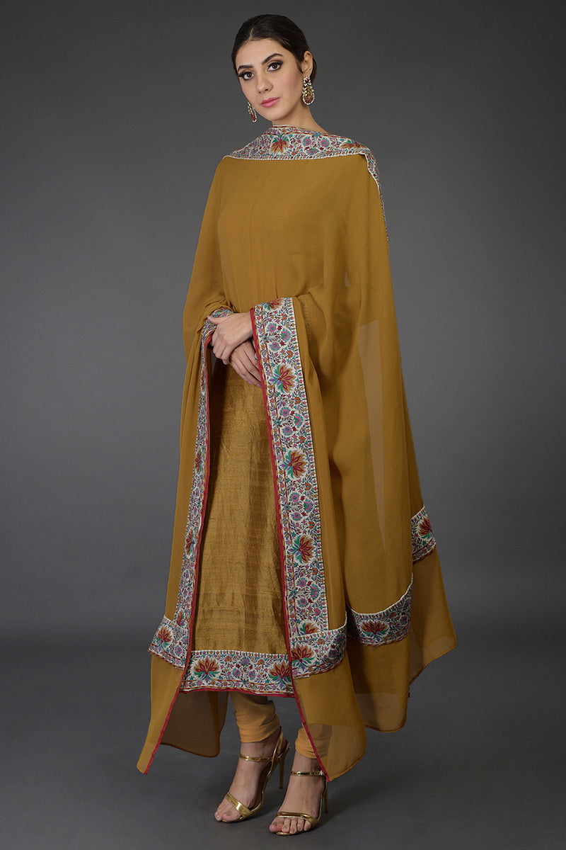 Dark mustard raw silk suit with multicolor Kashmiri hand embroidery and georgette dupatta borders.