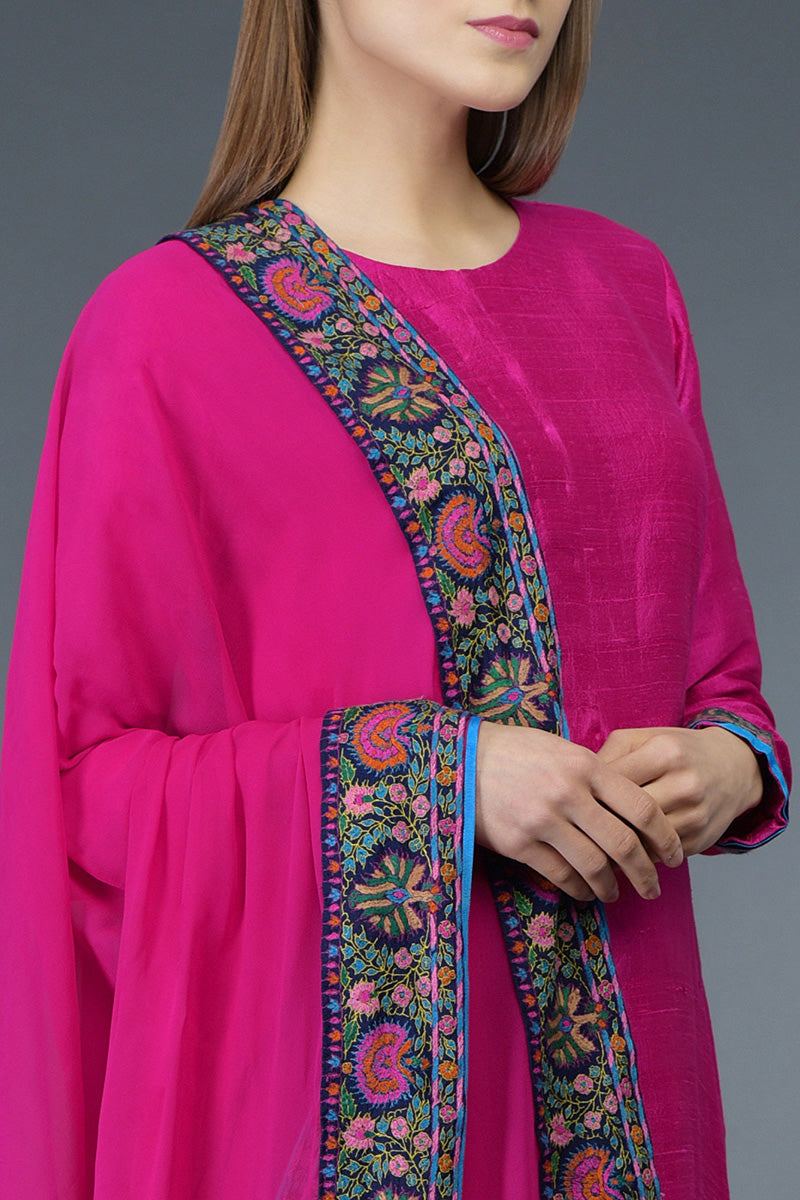 Hot pink raw silk suit with multicolor Kashmiri hand embroidery and georgette dupatta borders.
