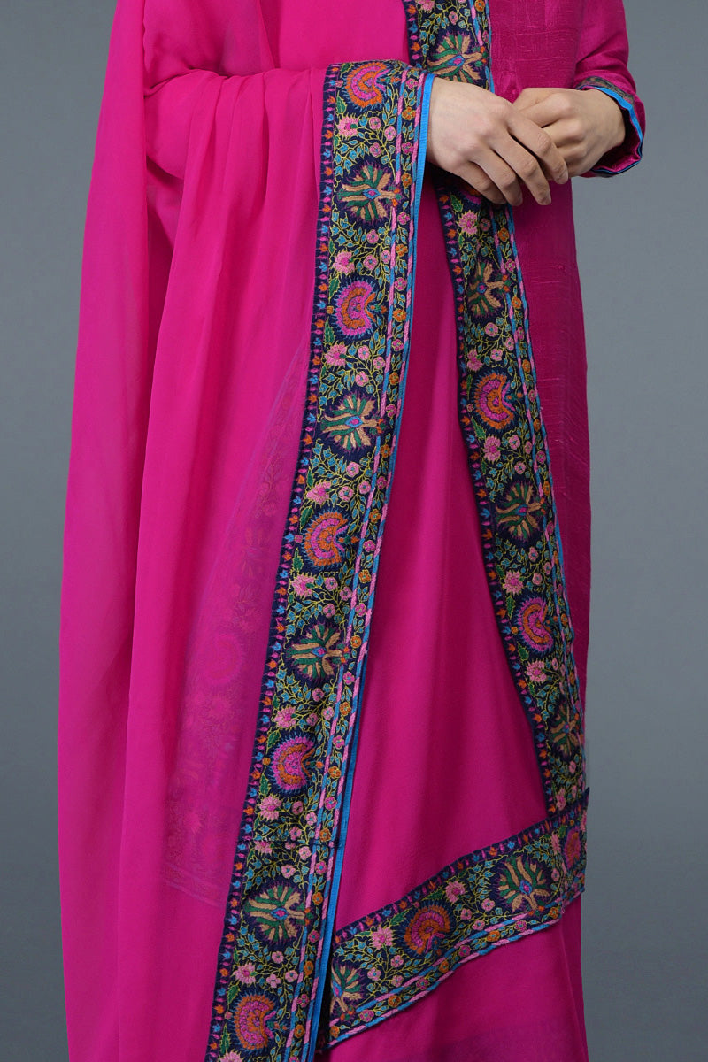 Hot pink raw silk suit with jewel neckline and multicolor Kashmiri hand embroidery on shirt and dupatta.