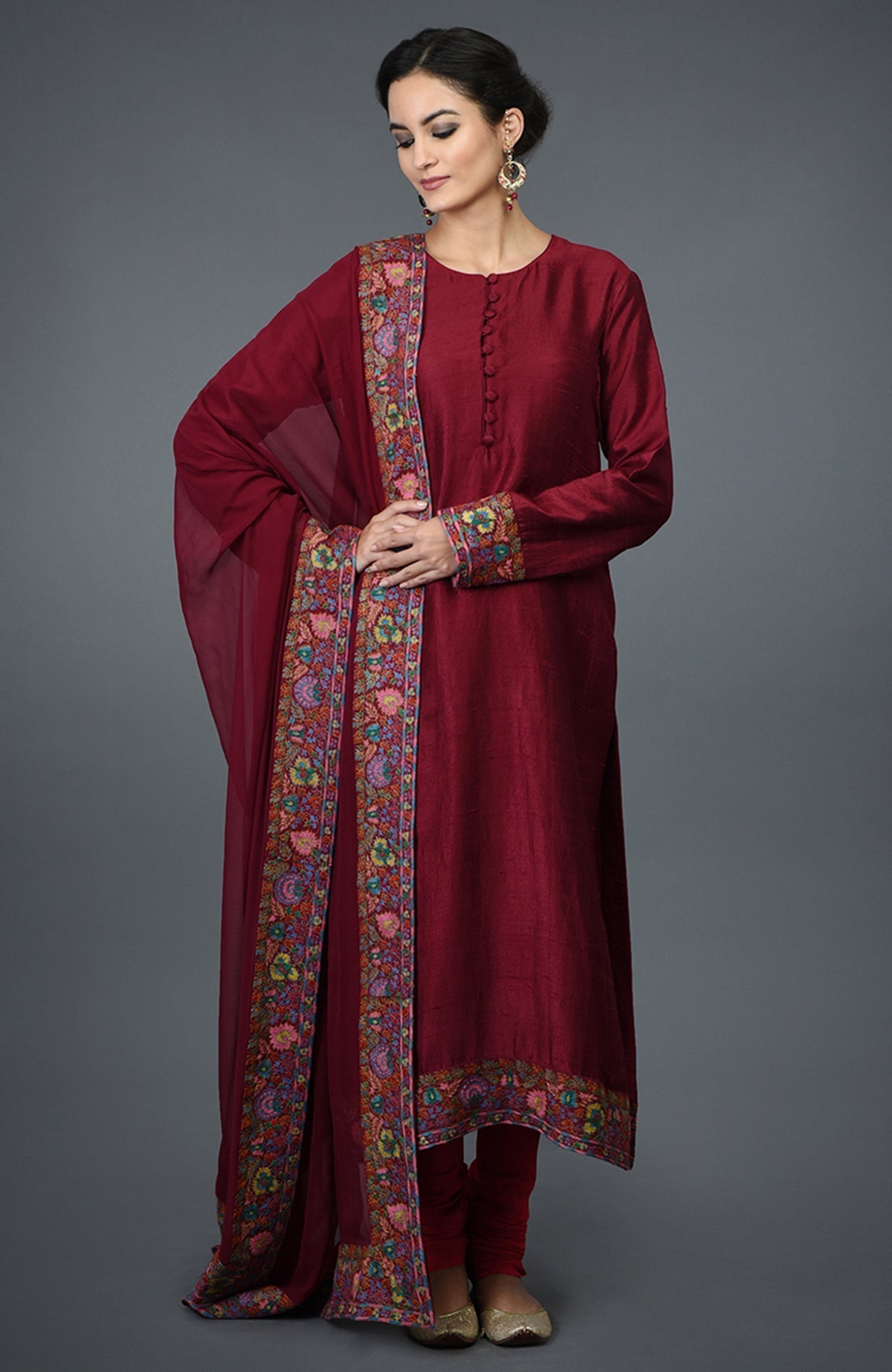 Maroon raw silk suit with jewel neckline and colorful Kashmiri hand embroidery on kurta and dupatta.