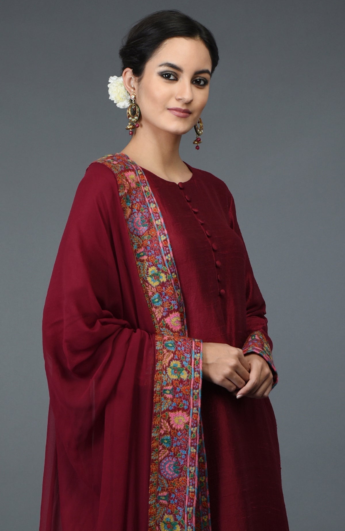Maroon raw silk suit with jewel neckline and multicolor Kashmiri hand embroidery on kurta and dupatta.