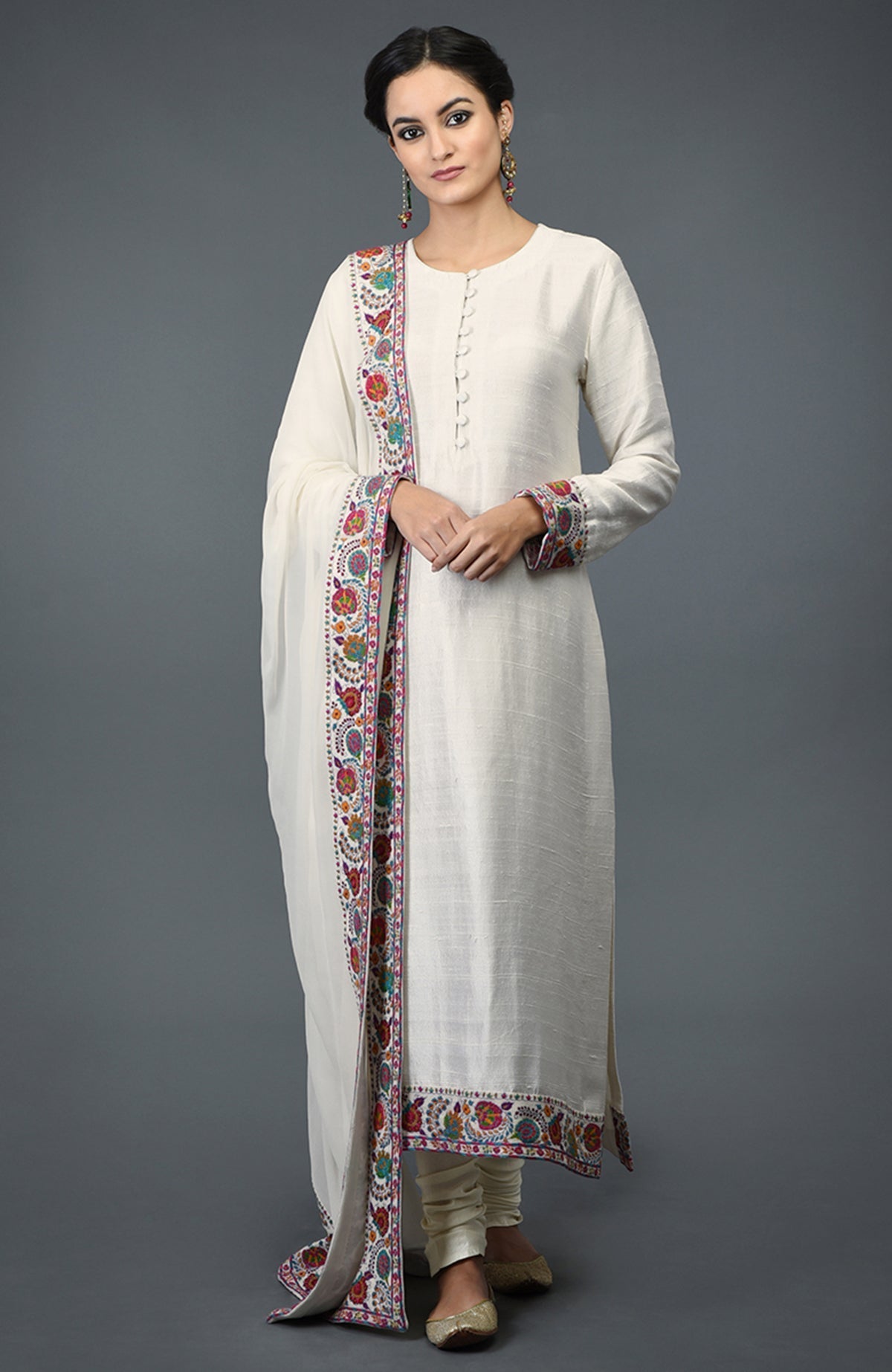 Ivory raw silk suit with colorful Kashmiri hand embroidery and georgette dupatta borders.