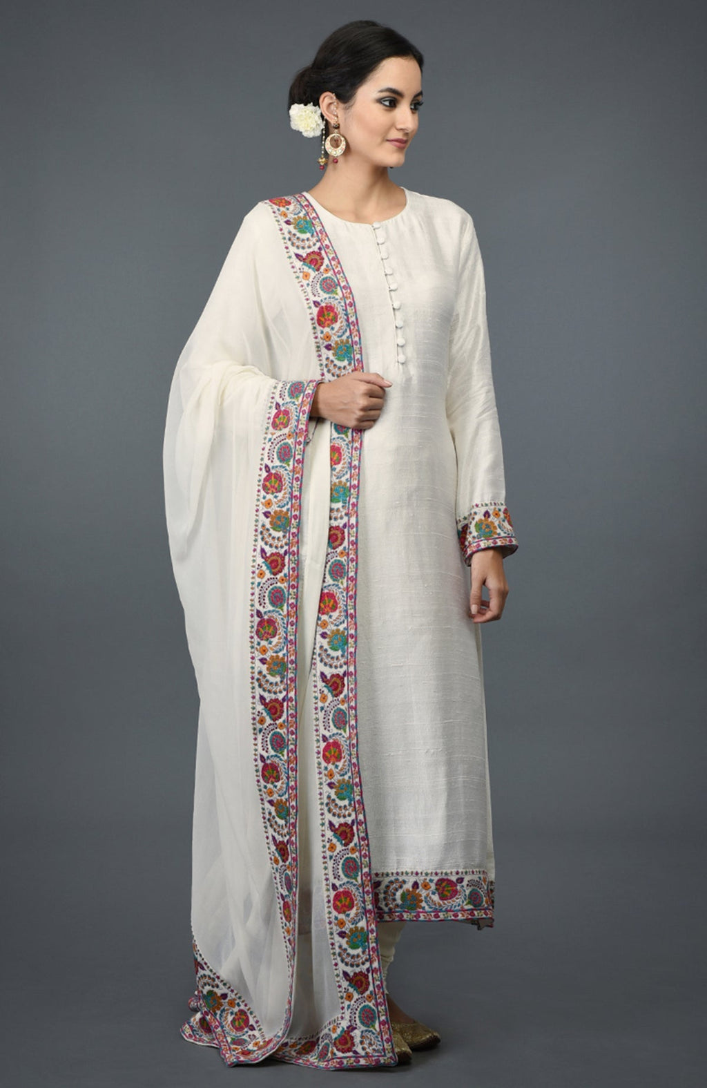 Ivory raw silk suit with colorful Kashmiri hand embroidery and georgette dupatta borders.