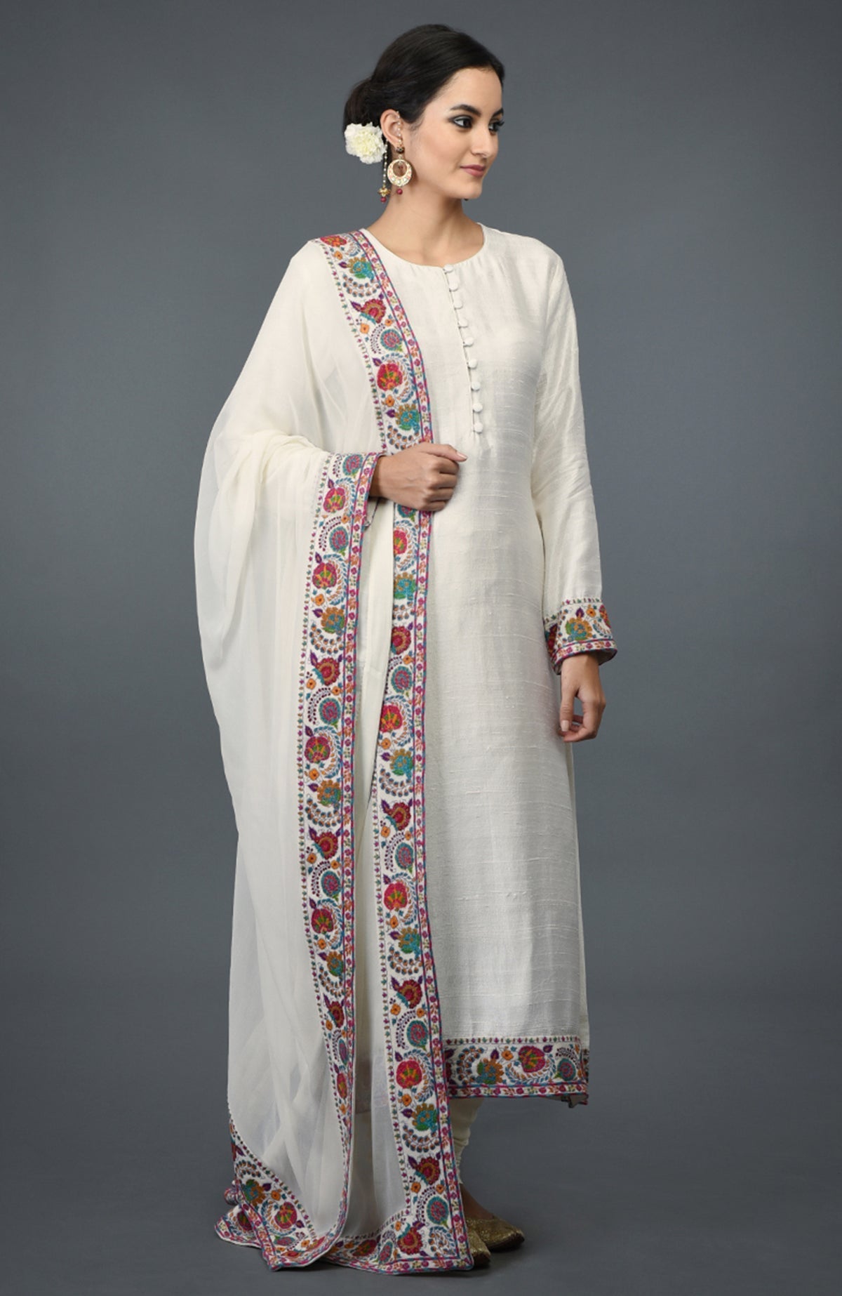 Ivory raw silk suit with colorful Kashmiri hand embroidery and georgette dupatta borders.