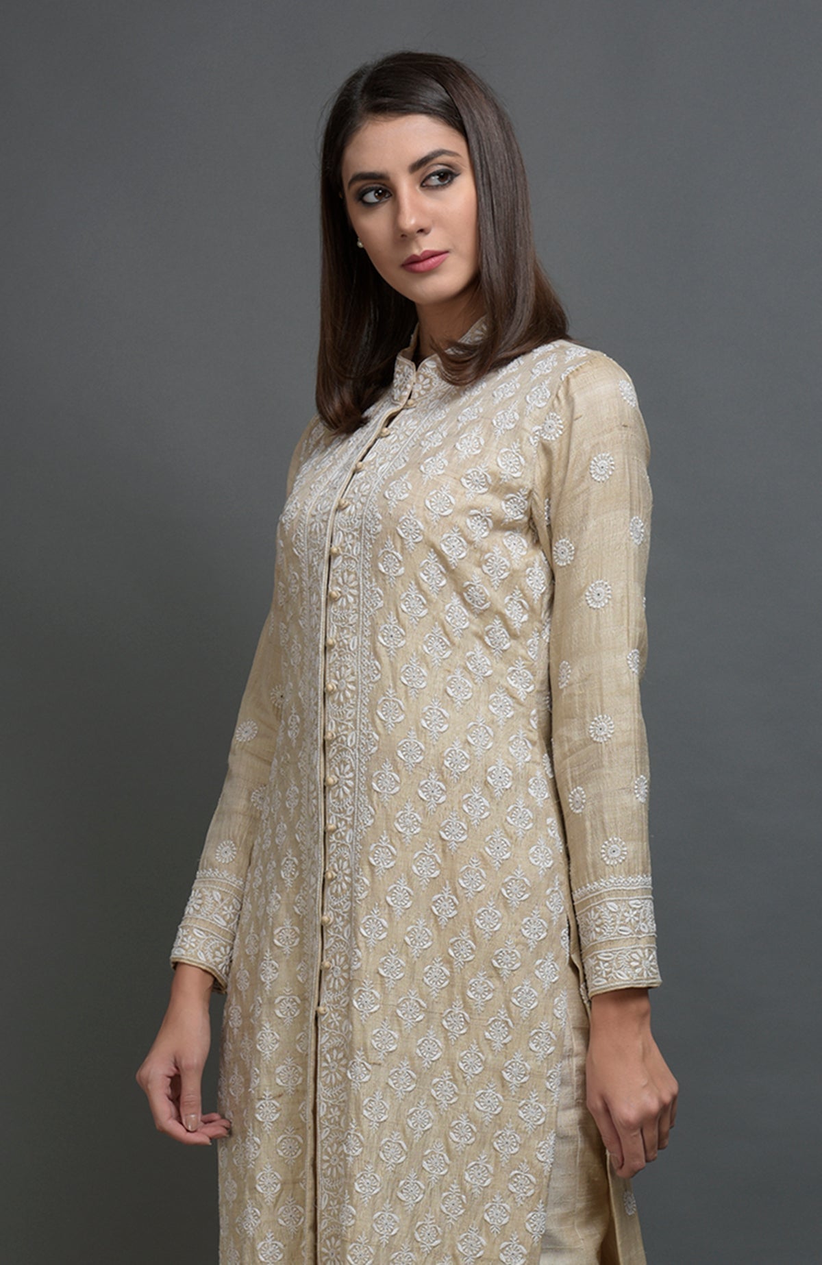 Champagne beige chikankari embroidered jacket suit with band collar and hook closures.