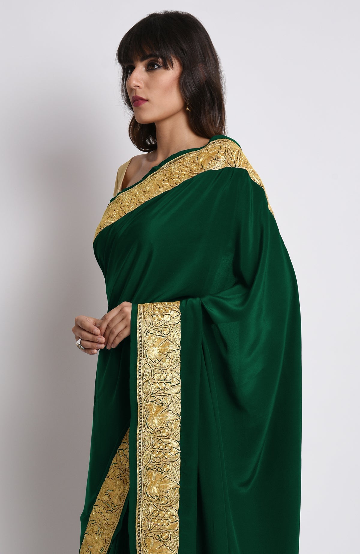 Emerald green crepe saree with gold Kashmiri tilla embroidery on pallav and borders