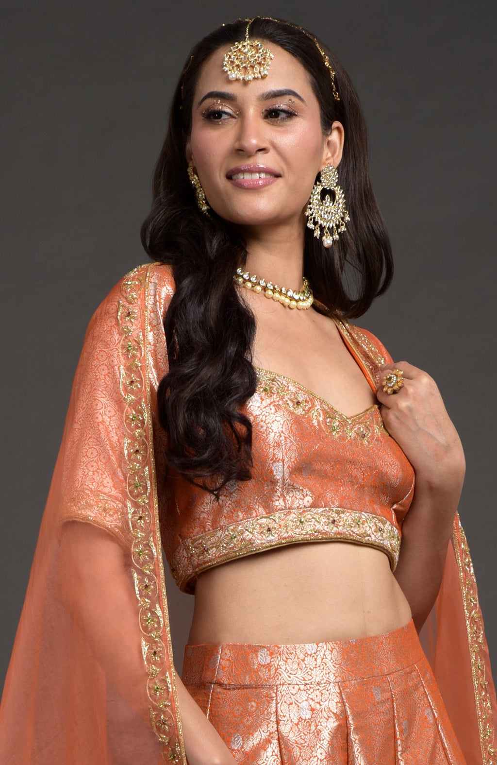 Orange-gold Benarasi blouse with zardozi floral embroidery and cut bead detailing.