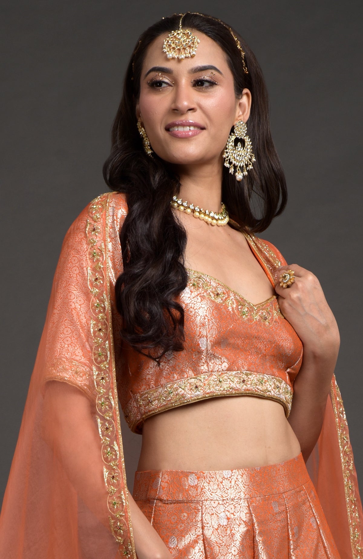 Orange-gold Benarasi blouse with zardozi floral embroidery and cut bead detailing.