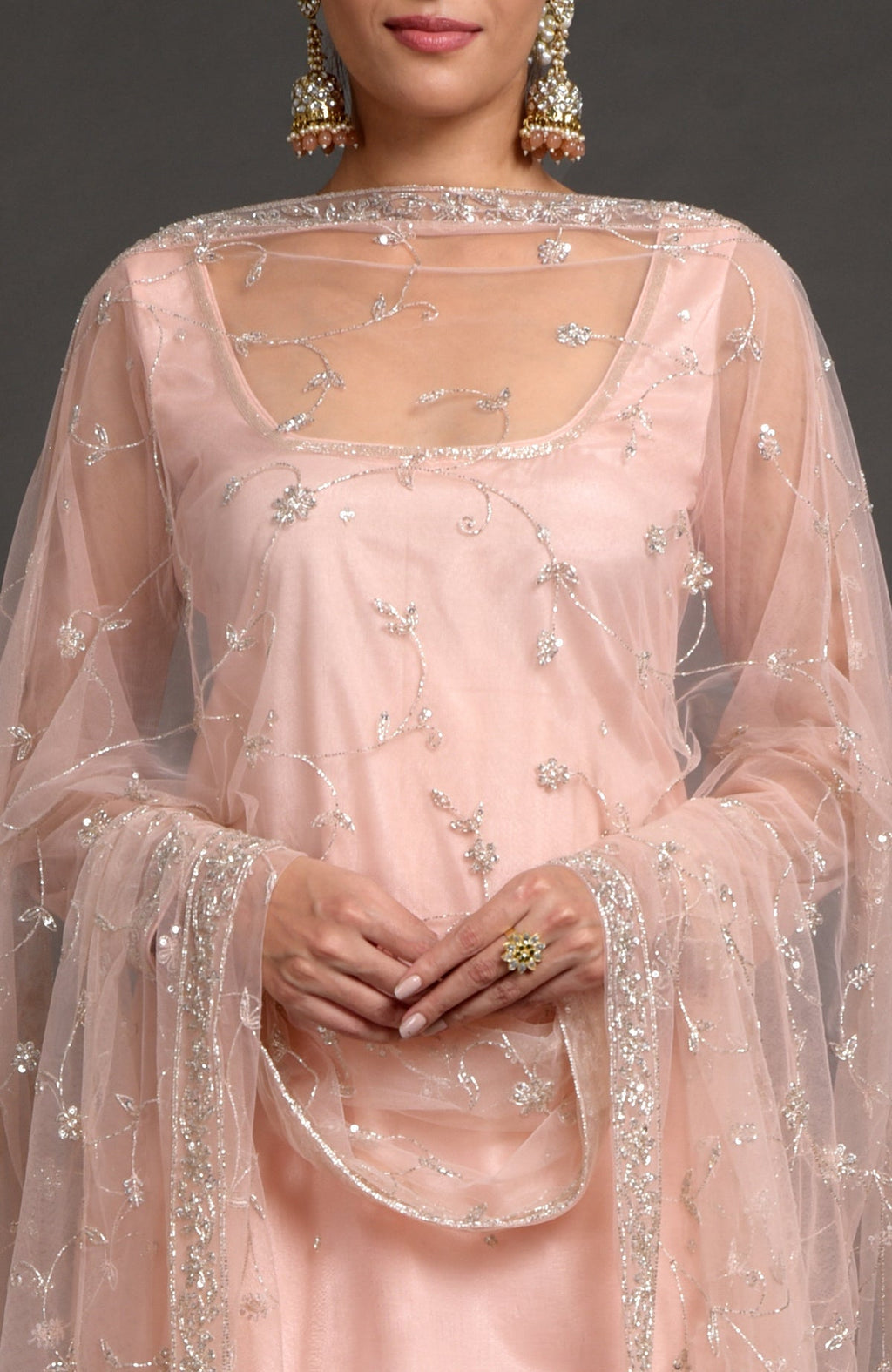 Nude pink tulle sharara set with zardozi embroidery and sheer sleeves with floral dupatta.