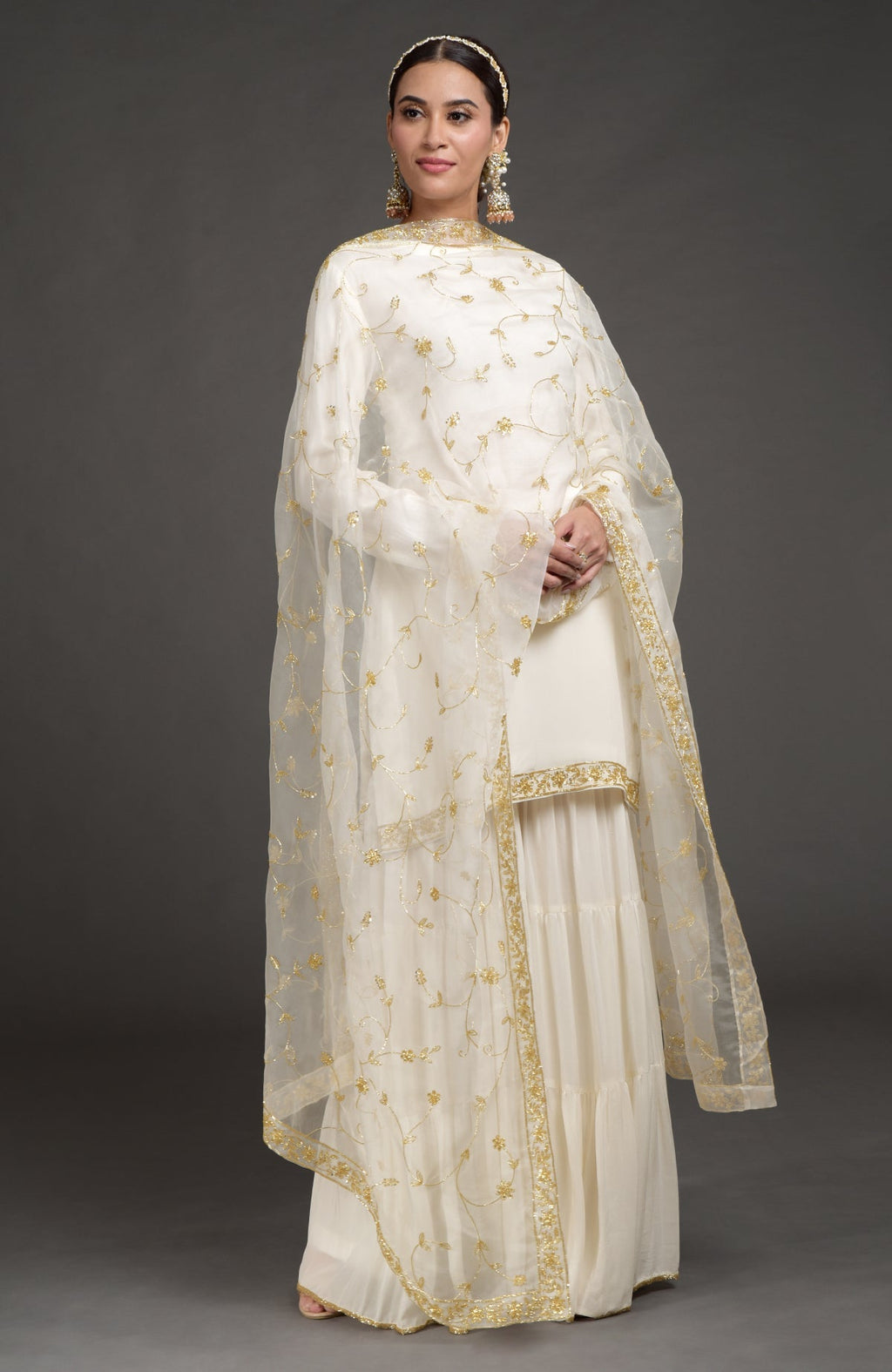 Ivory crepe silk gharara set with gold zardozi bead and sequin hand embroidery details.