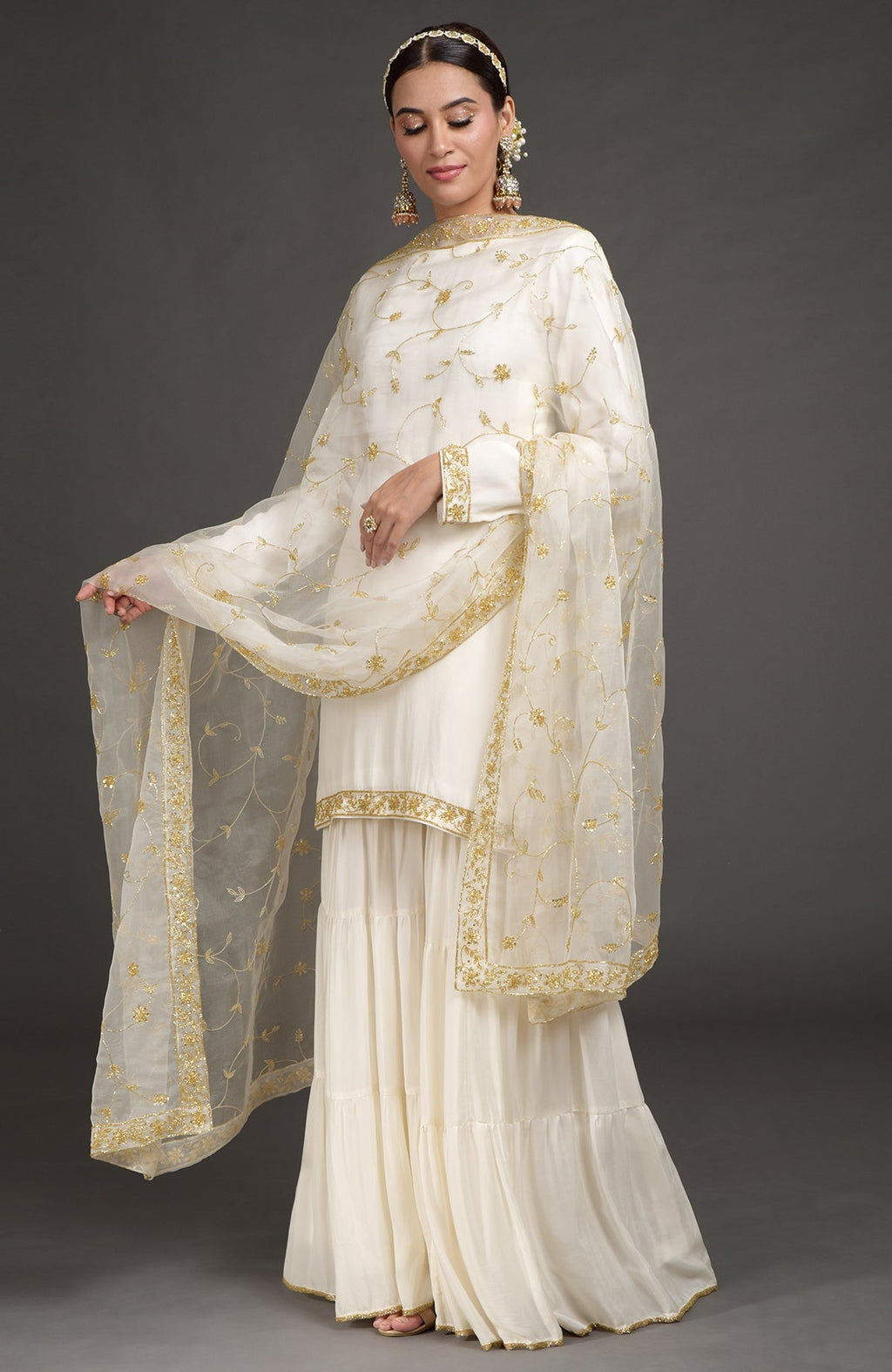 Ivory crepe silk gharara set with gold zardozi bead and sequin hand embroidery.
