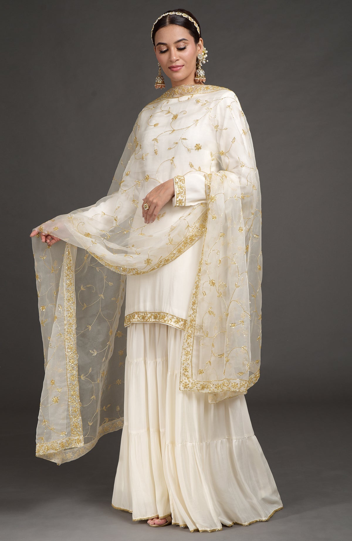Ivory crepe silk gharara set with gold zardozi bead and sequin hand embroidery.