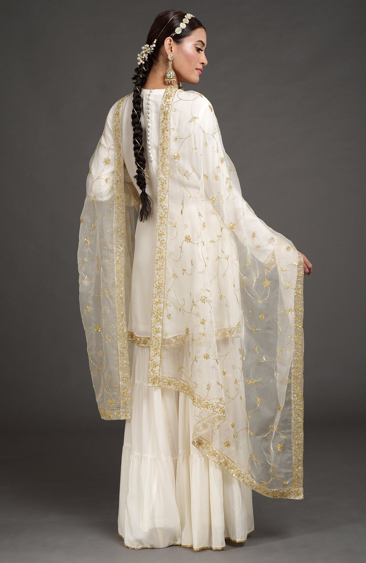 Ivory crepe silk gharara set with gold zardozi bead and sequin hand embroidery.