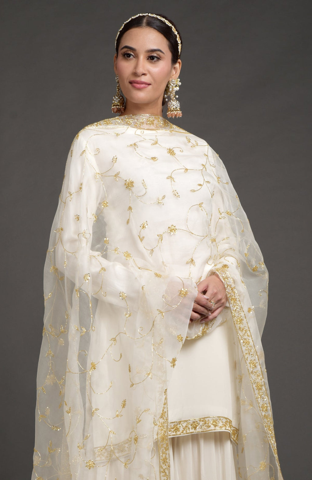 Ivory crepe silk gharara set with gold zardozi bead and sequin hand embroidery.