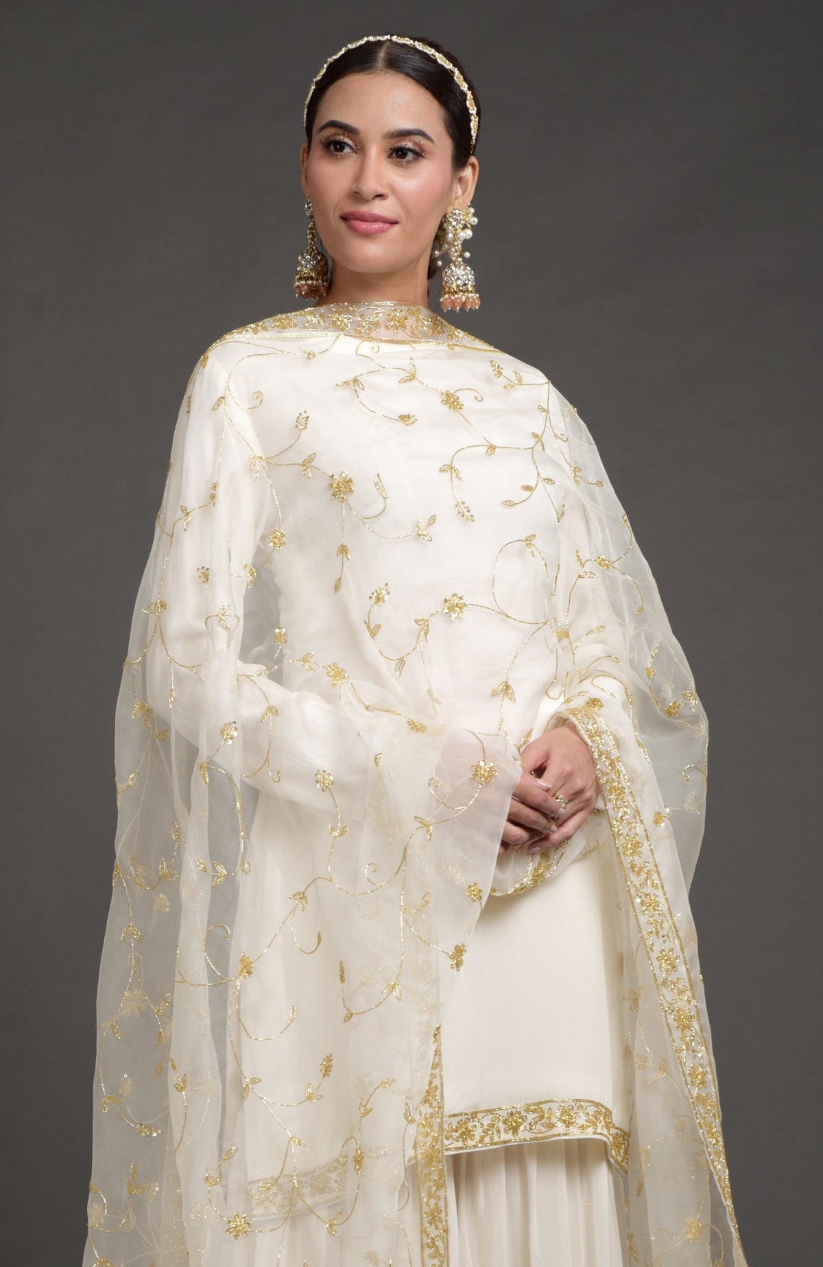 Ivory crepe silk gharara set with gold zardozi bead and sequin hand embroidery.