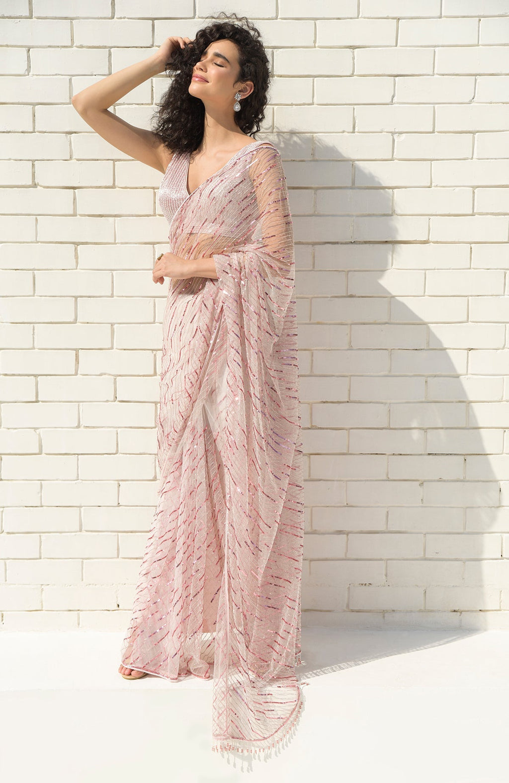 Pink saree with hand embroidered sequins, beads, and matching blouse with V-neckline.
