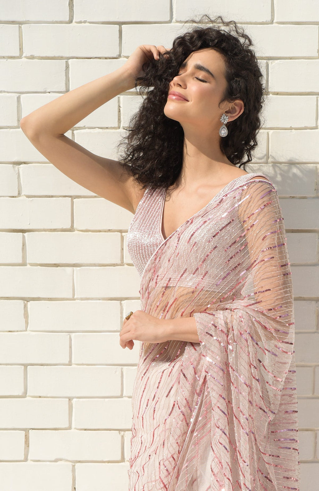 Pink saree with hand-embroidered sequins, beads, and matching blouse with V-neckline.
