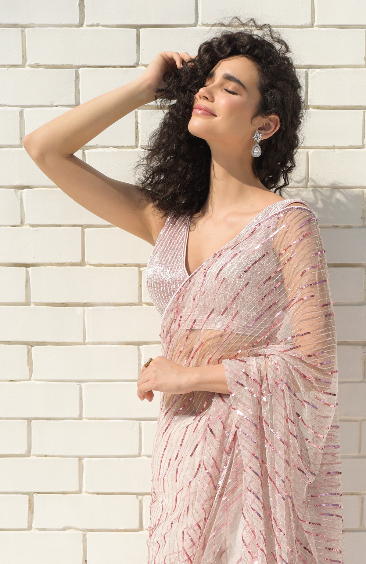 Pink saree with hand-embroidered sequins, beads, and matching blouse with V-neckline.
