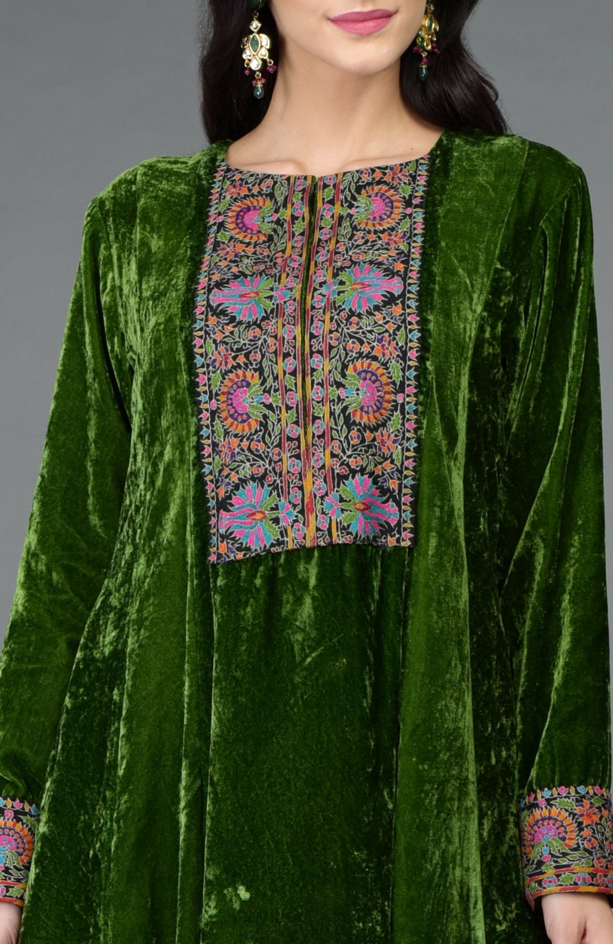 Green silk velvet kurta with asymmetrical hem and colorful Kashmiri hand embroidery on neck and sleeves