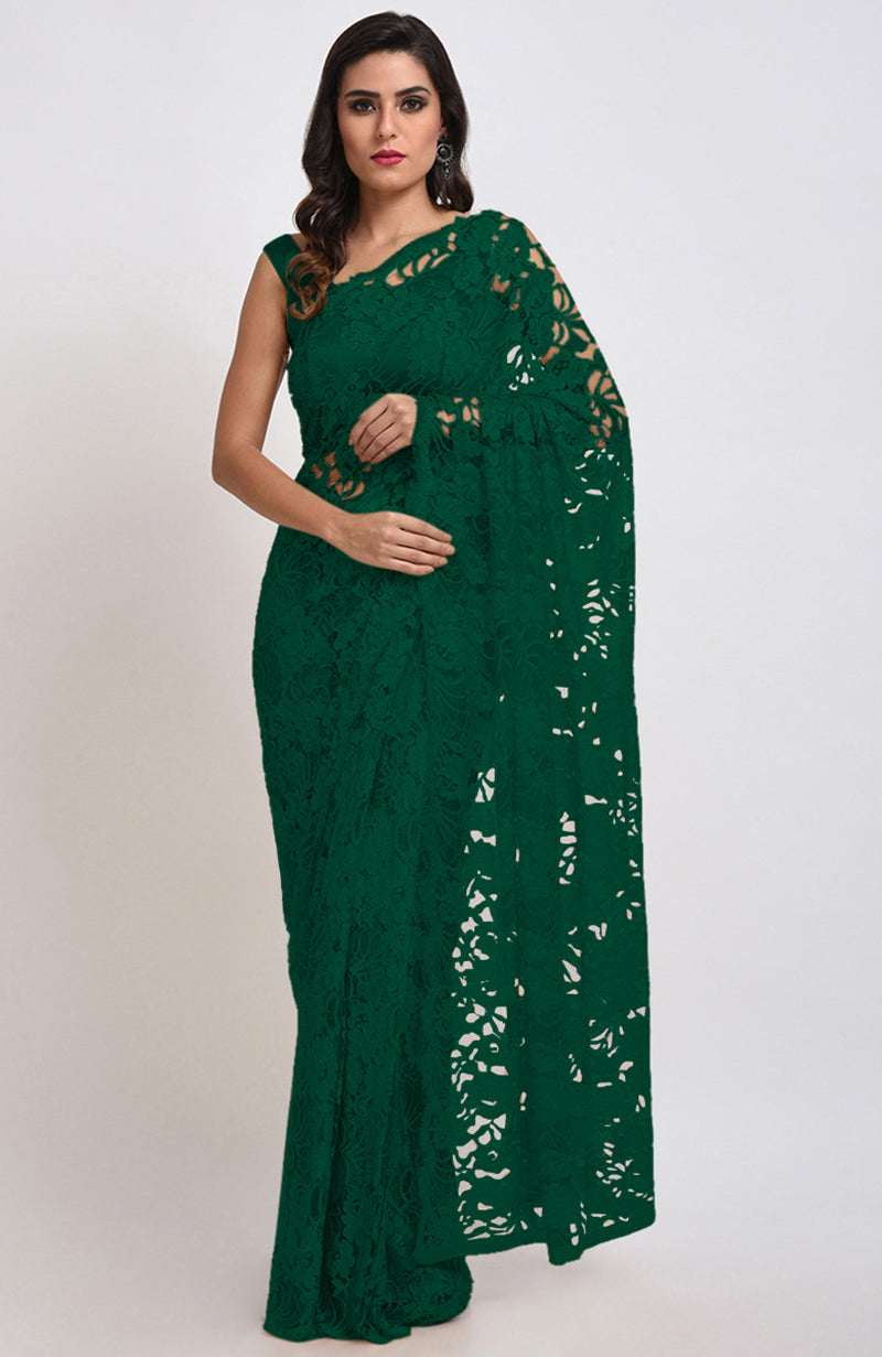 An elegant woman models an emerald green Chantilly lace saree.