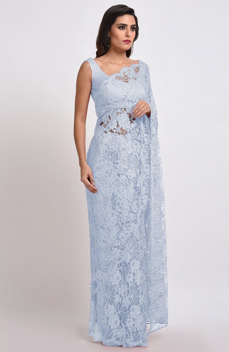 A woman models an illusion blue French Chantilly lace saree.