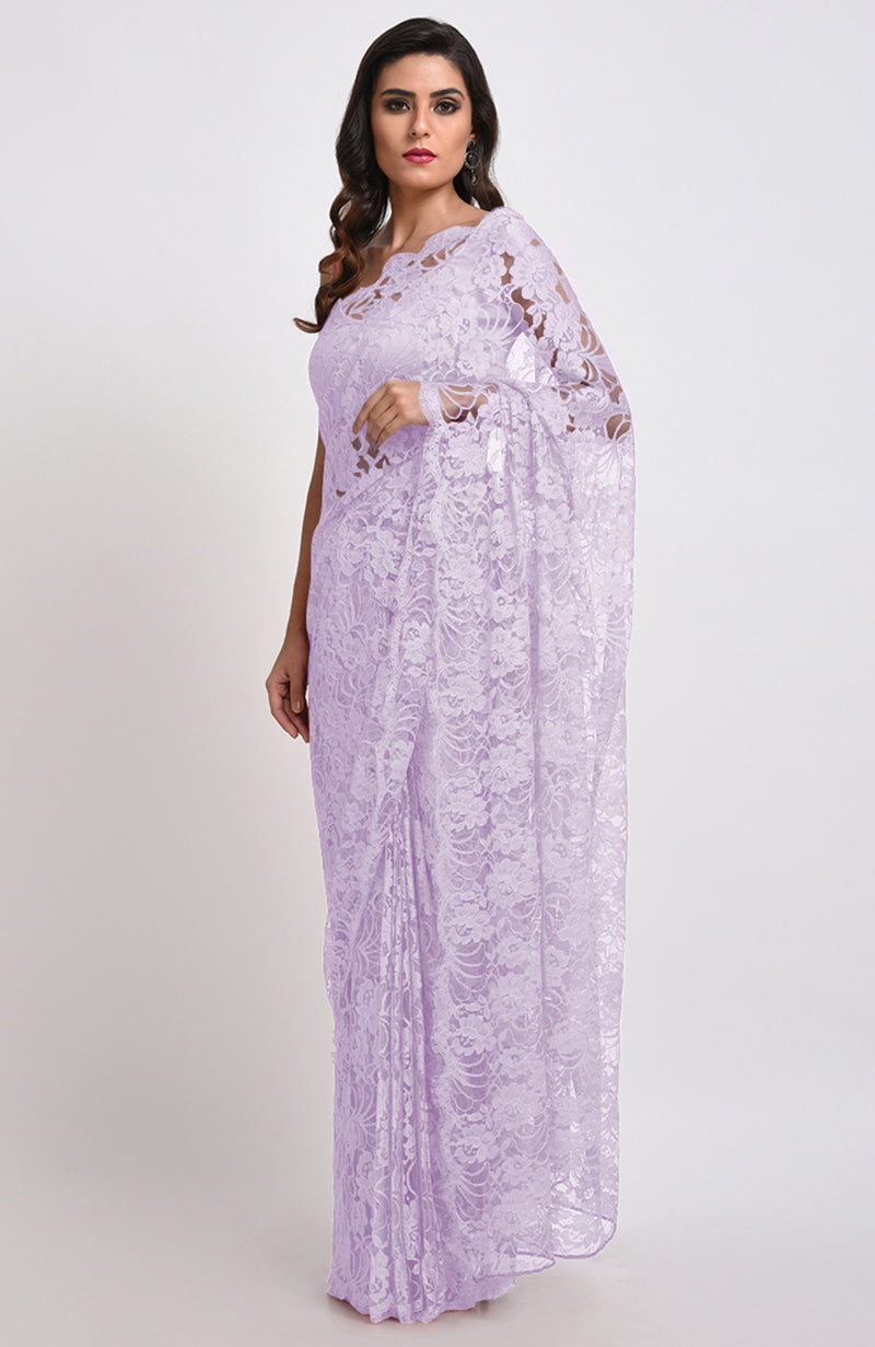 A woman models a lavender Chantilly lace saree with a matching blouse.