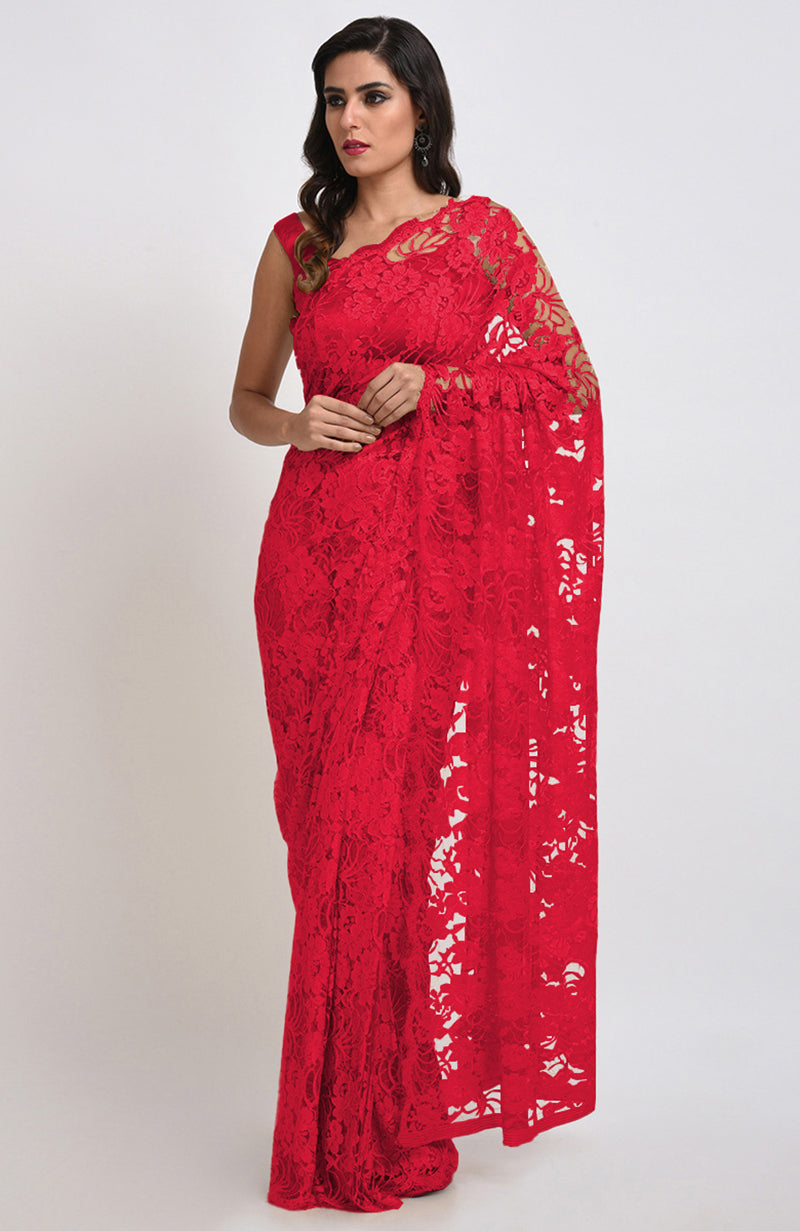 A woman models a red Chantilly lace saree with a matching blouse.