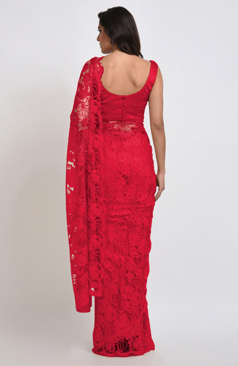 A woman models a red Chantilly lace saree with a matching satin blouse.