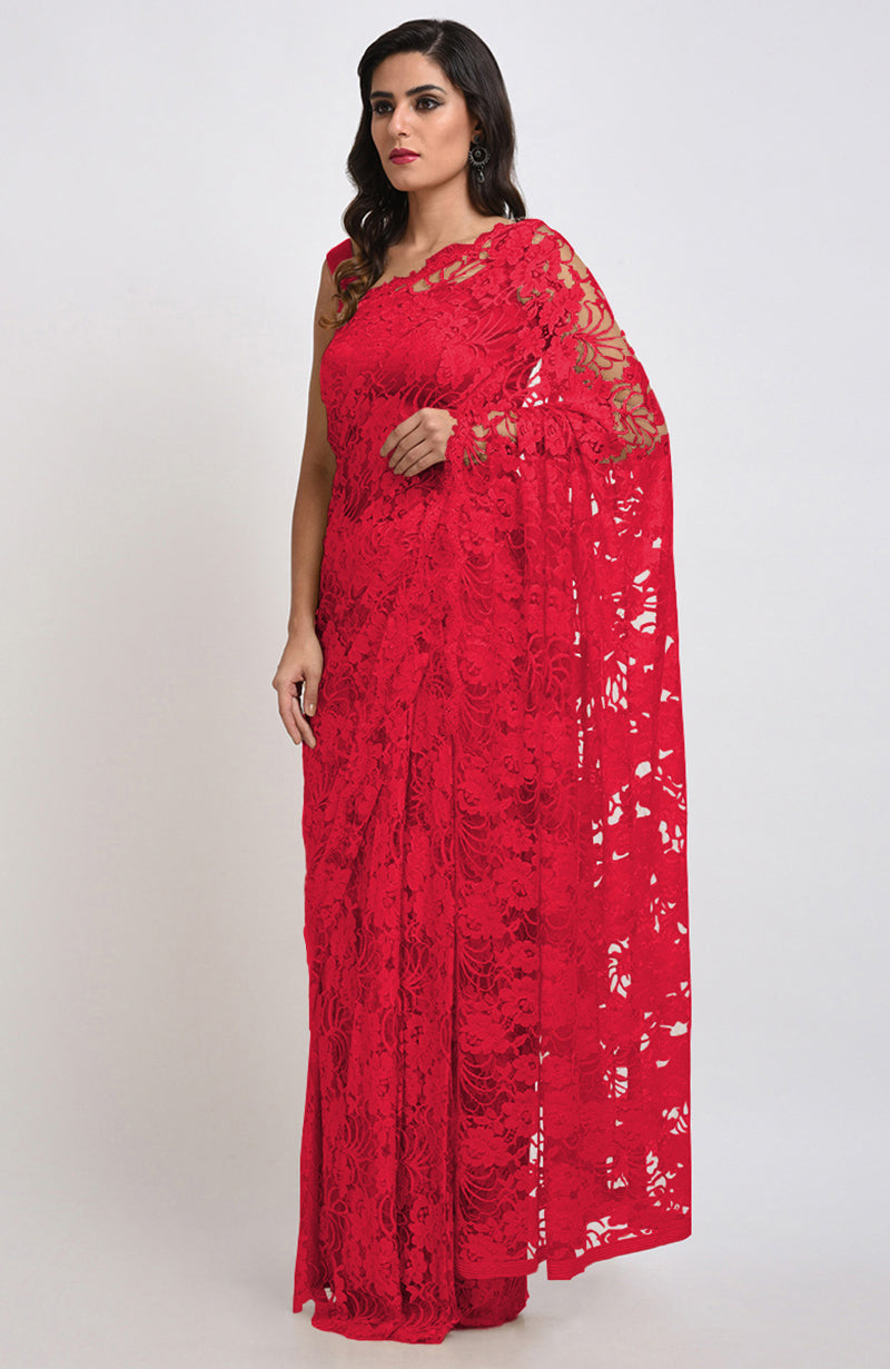 A woman models a red Chantilly lace saree with a matching blouse.