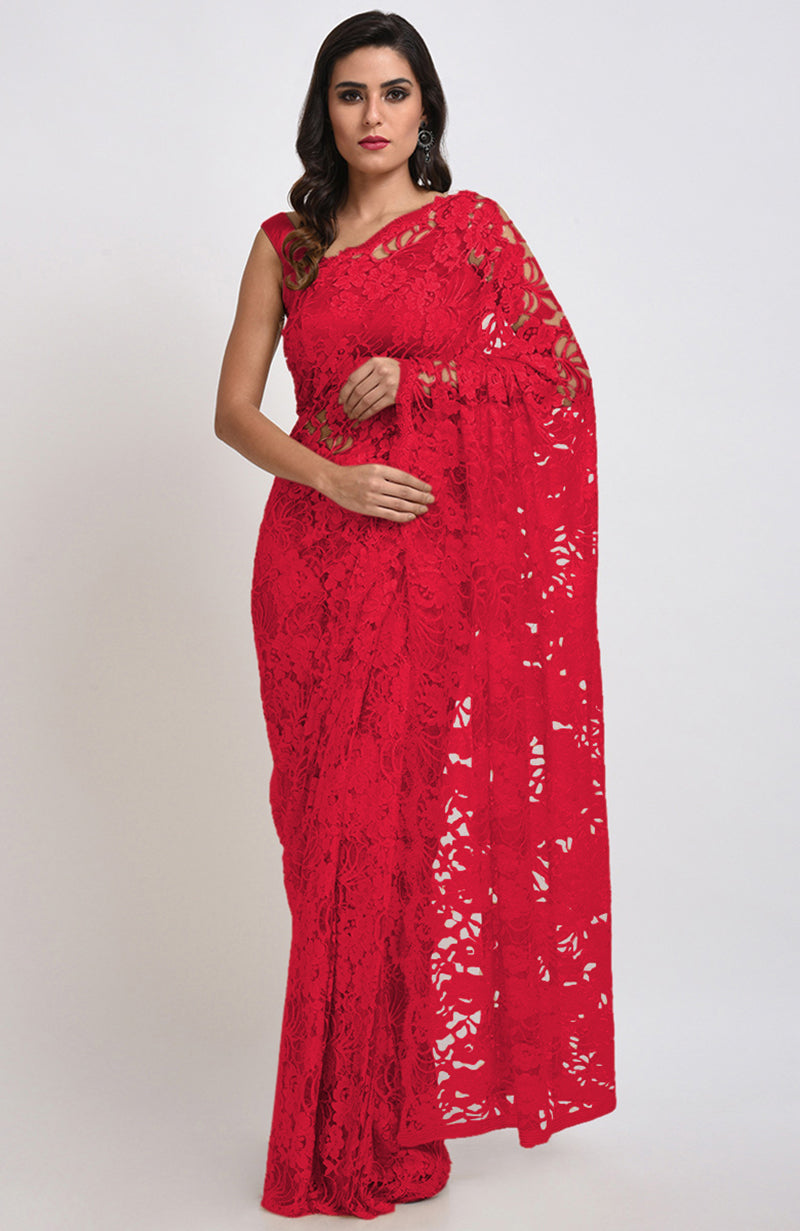 A woman models a red Chantilly lace saree with a matching blouse.