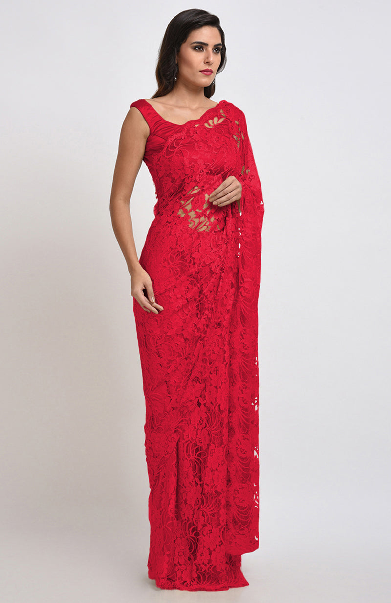 A woman models a red Chantilly lace saree with a matching blouse.