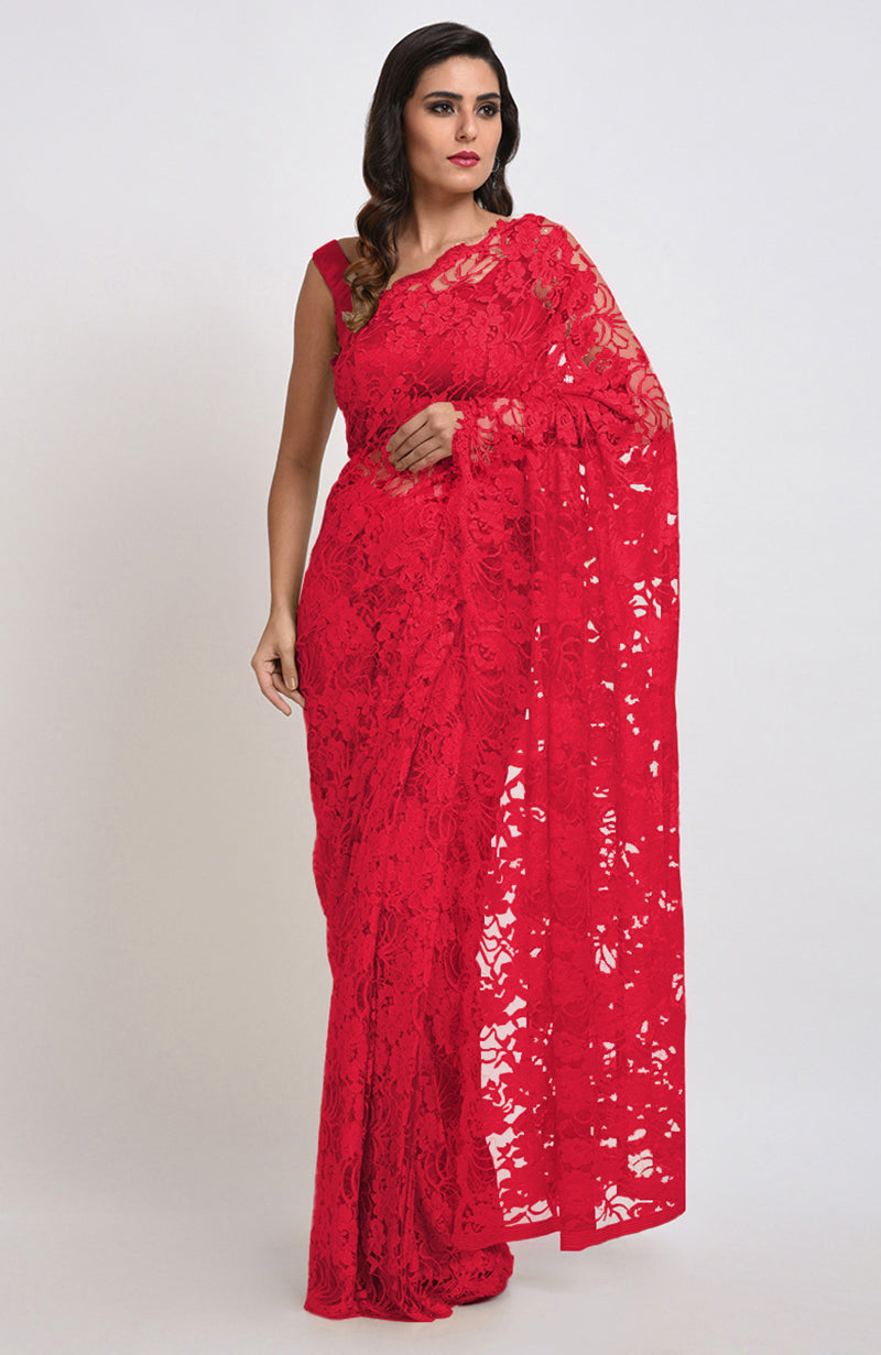 A woman models a red Chantilly lace saree with a matching blouse.