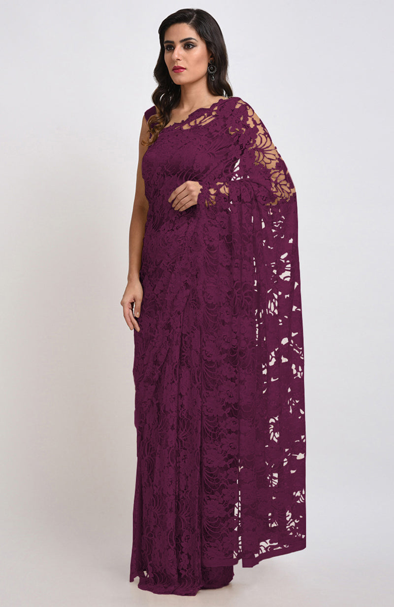 A woman models a wine Chantilly lace saree with a matching blouse.