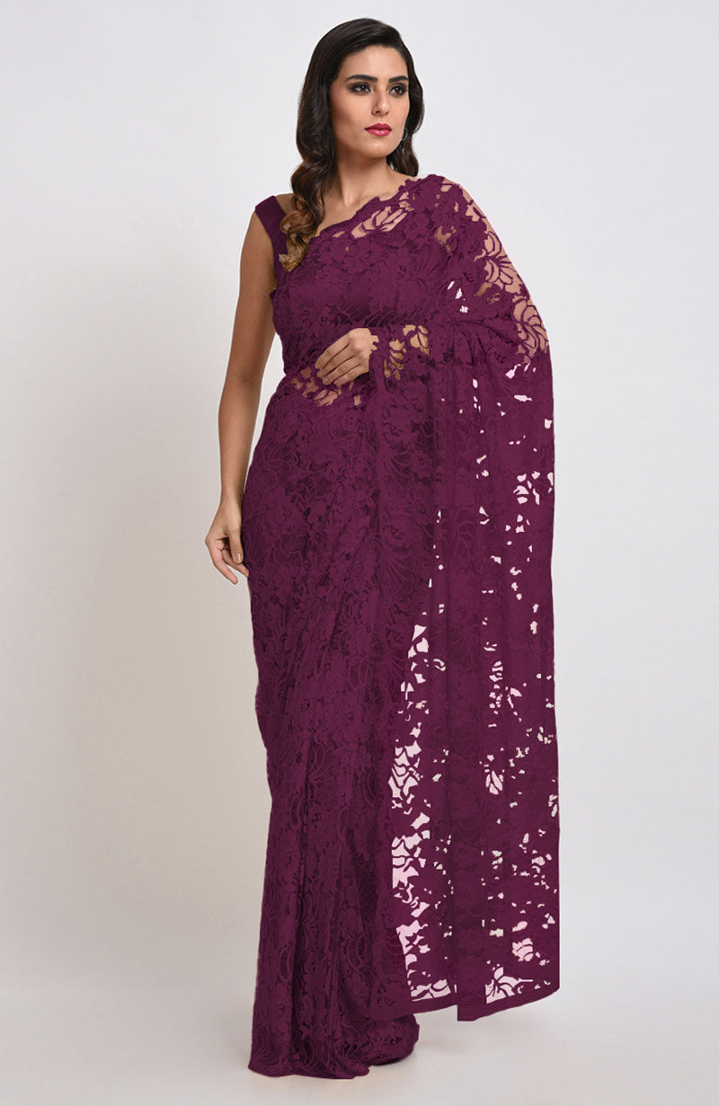 A woman models a wine Chantilly lace saree with a matching blouse.