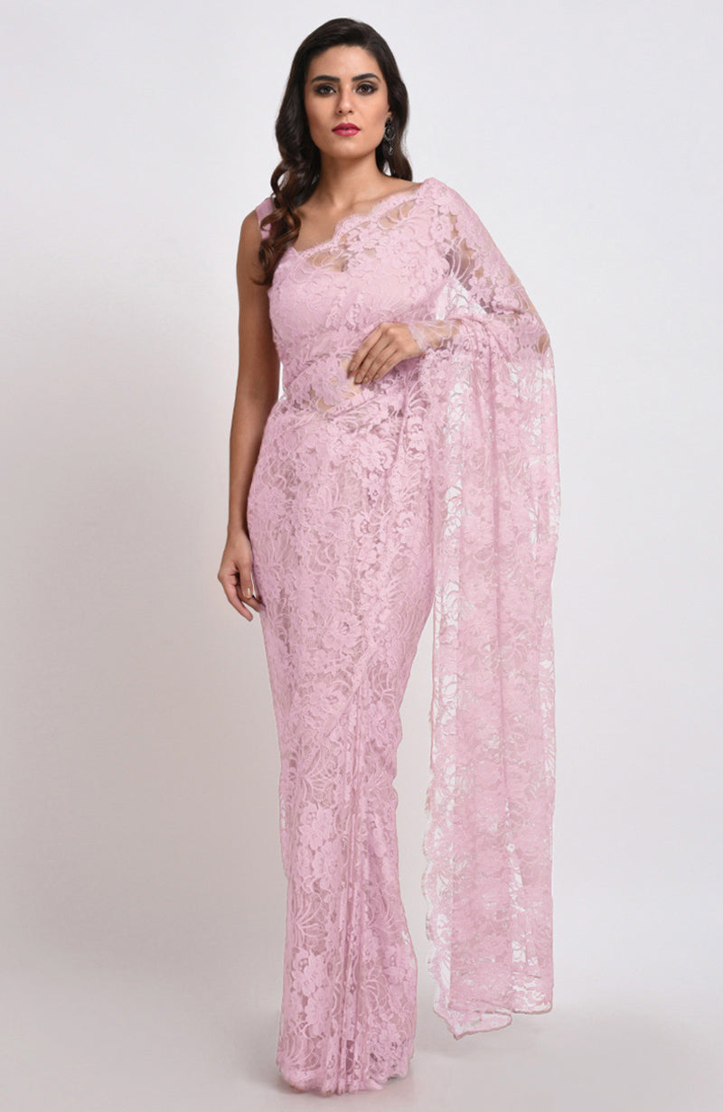 A woman models a pink French Chantilly lace saree with a matching blouse.