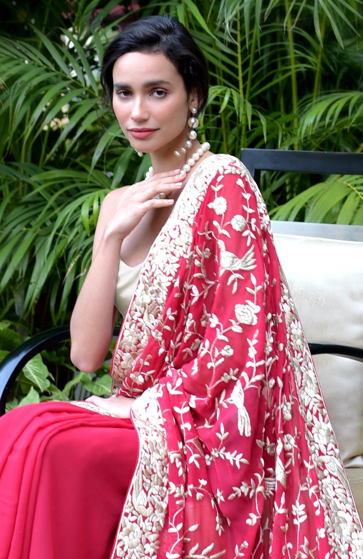 Apple red saree with hand-embroidered Parsi Gara floral and bird motifs in beige and brown.