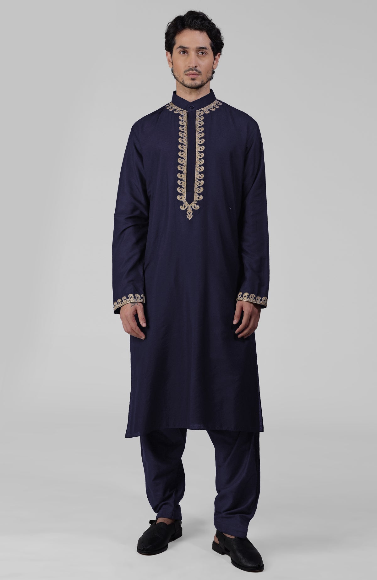 Black silk kurta with gold Kashmiri tilla embroidery paired with a black pathani salwar.