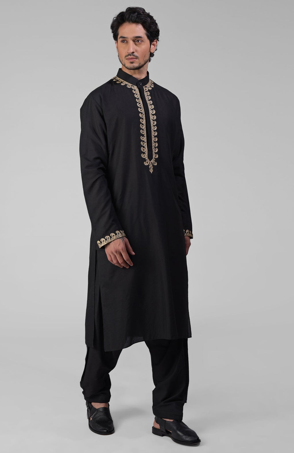 Black silk kurta with gold Kashmiri tilla embroidery paired with a matching pathani salwar.