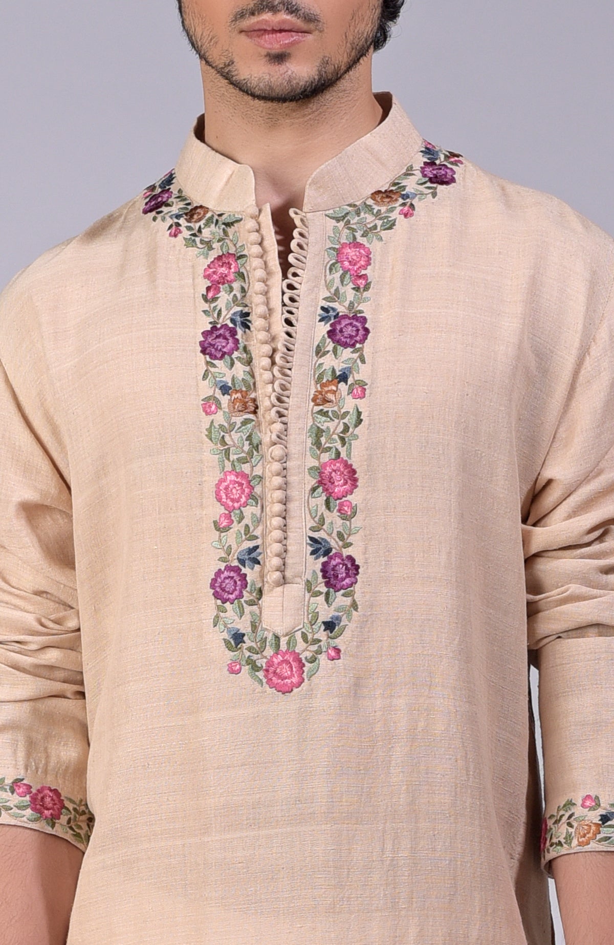 Beige kurta with multicolor Parsi Gara embroidery on placket, neckline, and sleeves.