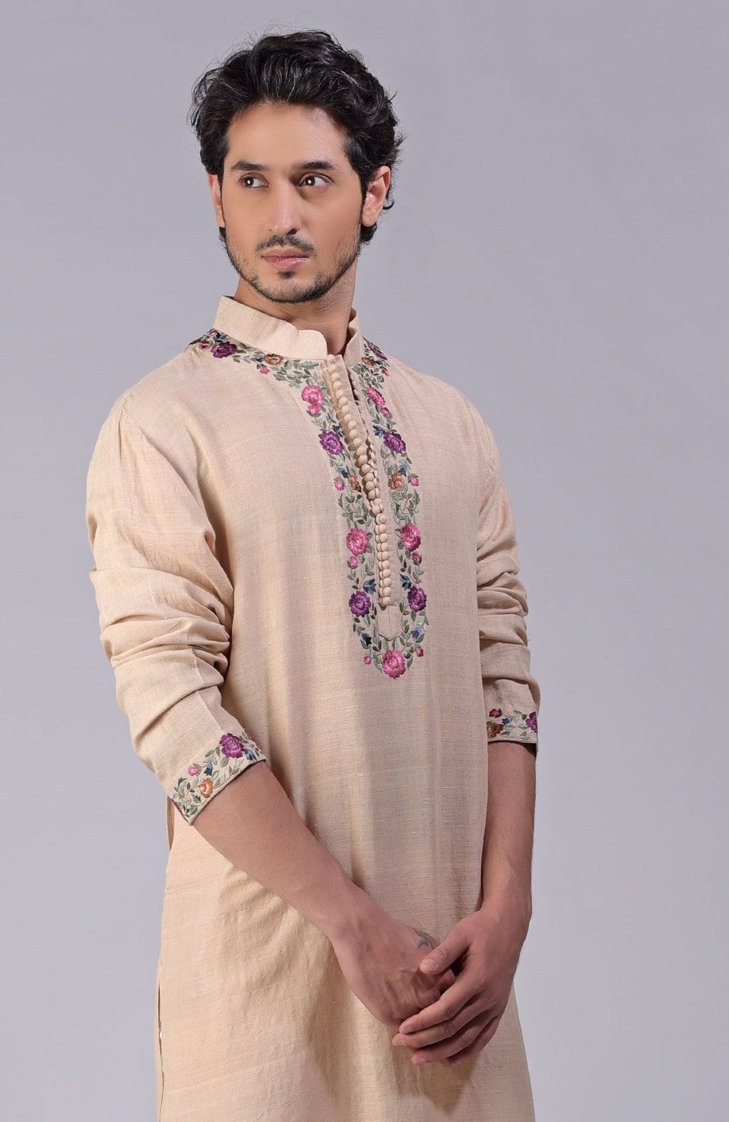 Beige kurta with multicolor Parsi Gara embroidery on placket, neckline, and sleeves.