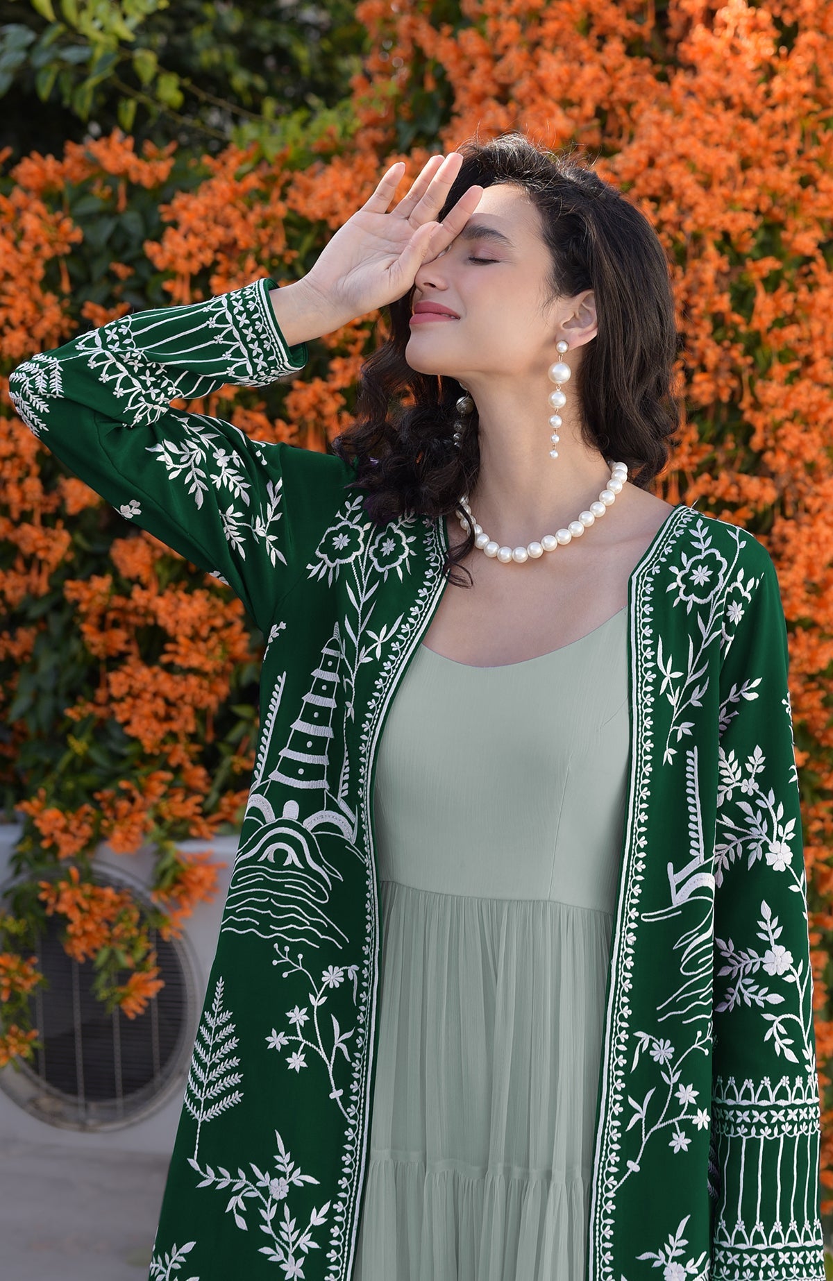 Emerald green Parsi Gara embroidered jacket with ivory motifs and sage green micropleated chiffon dress