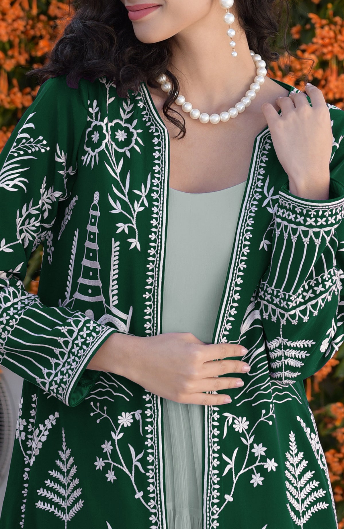 Emerald green Parsi Gara embroidered jacket with ivory motifs paired with sage green chiffon dress