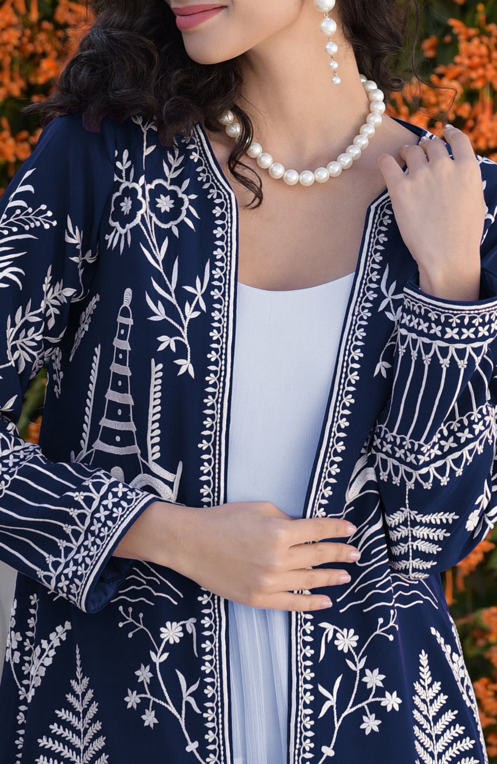 Navy blue Parsi Gara embroidered jacket with ivory motifs paired with powder blue micropleated chiffon dress