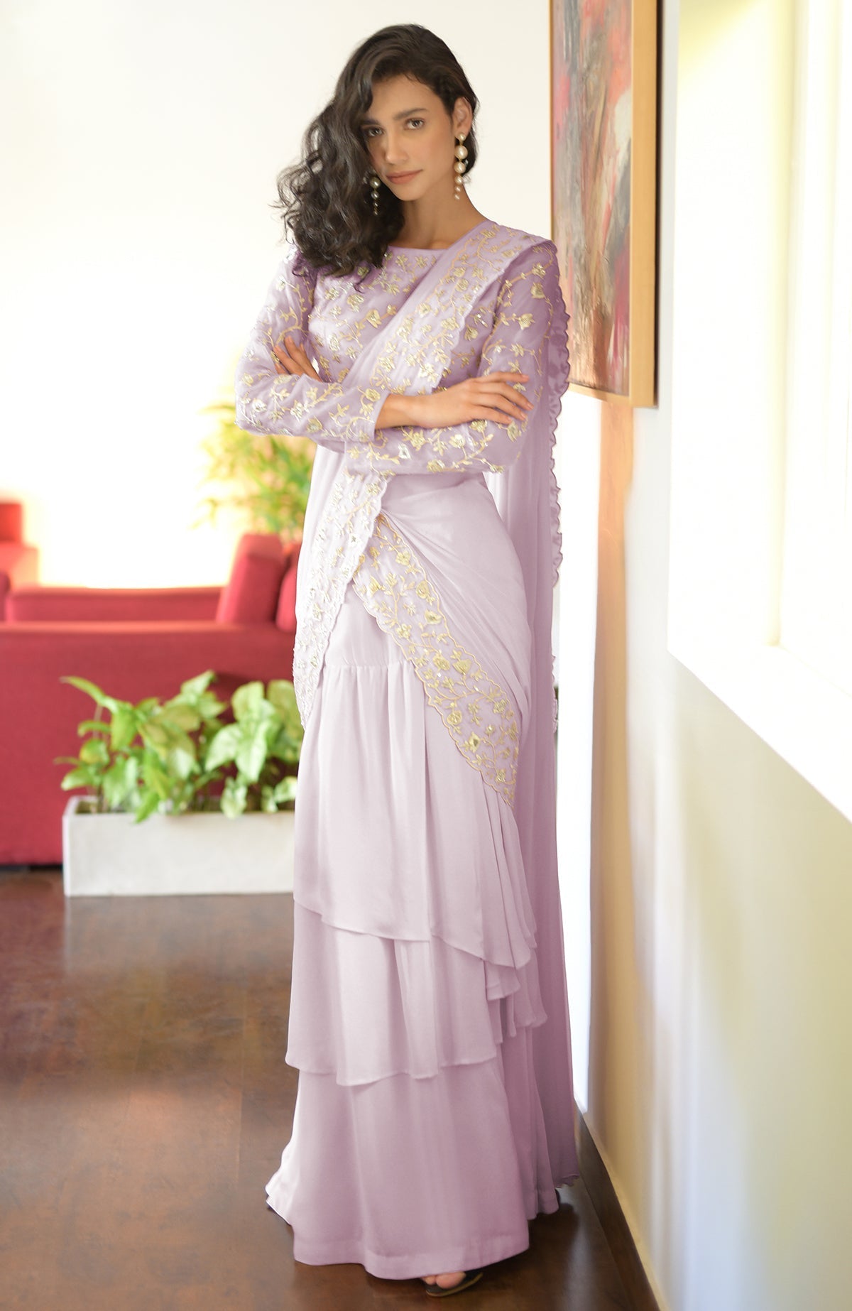 A woman in a lilac silver embroidered draped saree set with tiered ruffles.