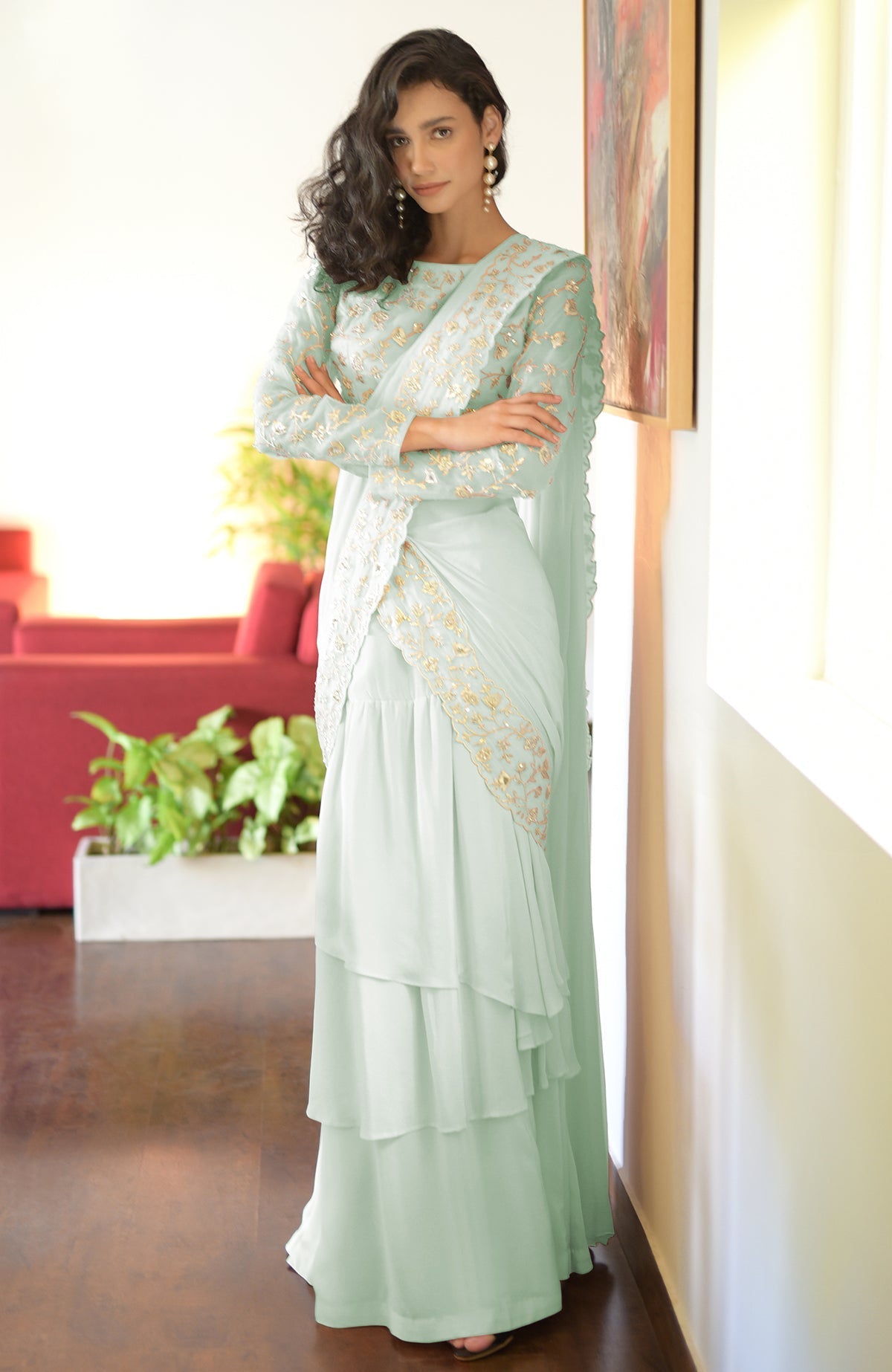 A woman models a lilac-silver embroidered draped saree set with a tiered skirt.