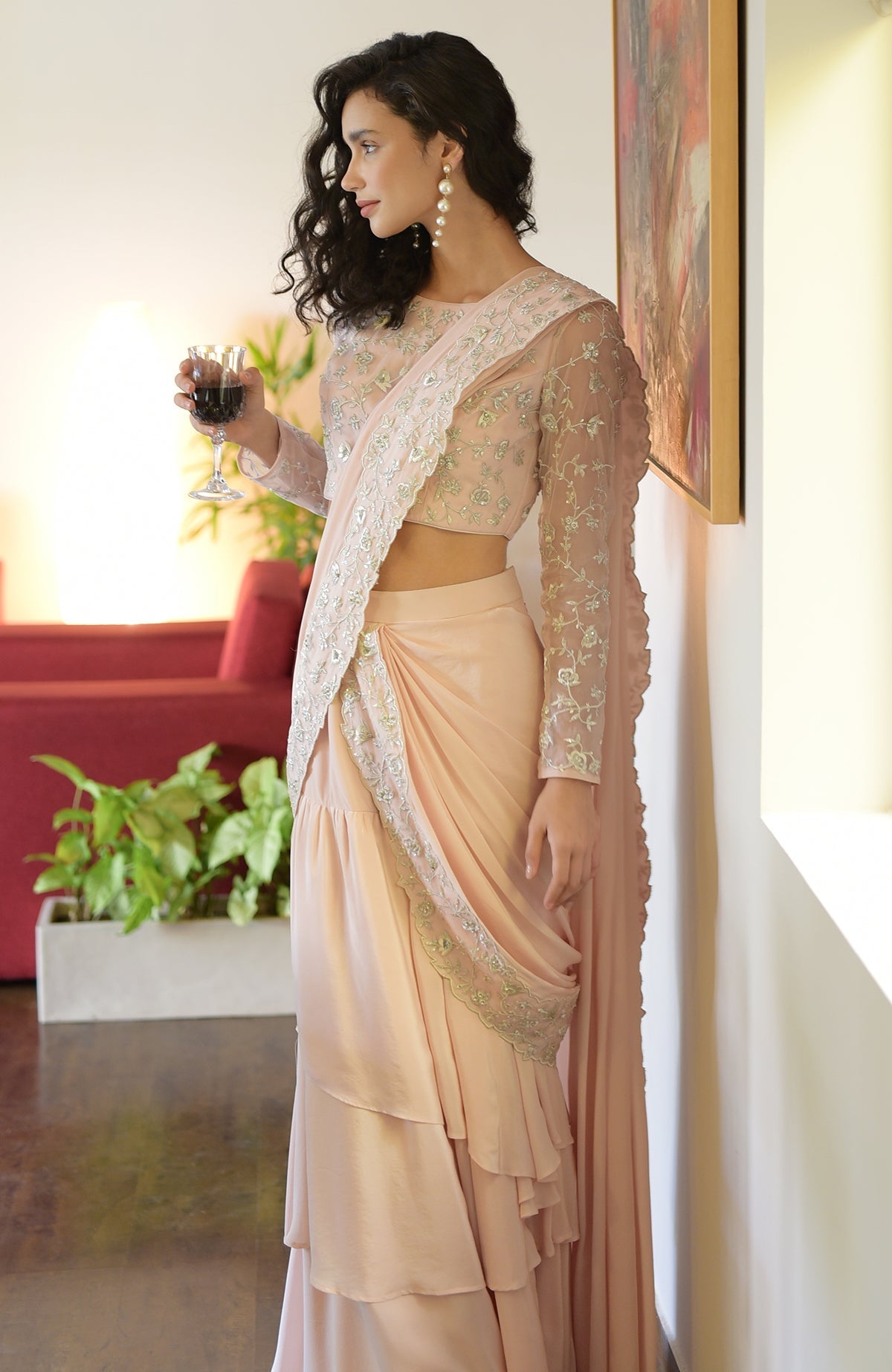 Nude pink saree with silver floral embroidery, scalloped borders, and a boat neck blouse with long sleeves
