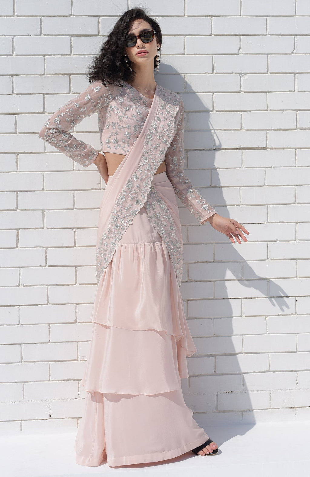Nude pink saree with silver floral embroidery and scalloped borders, paired with embroidered blouse.
